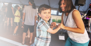 Joyful mom dancing with her son at a party.