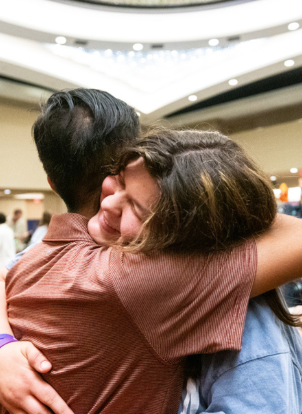 Two people hugging at a conferenc