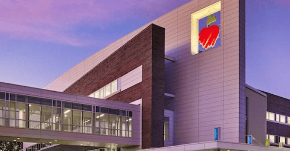 Photograph of a children's hospital at sunset with a heart logo